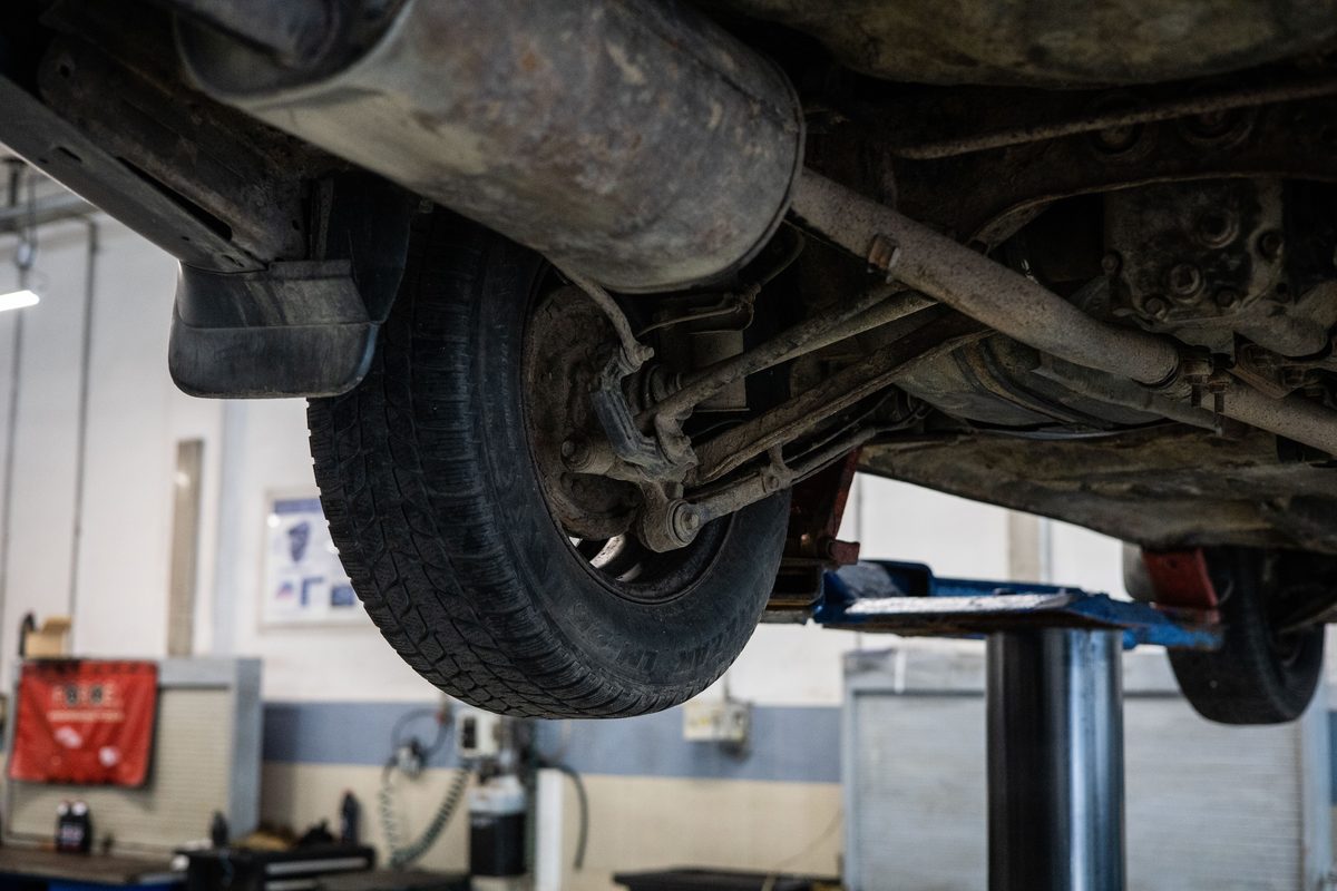 Car suspension and underside inspection on a lift during suspension repair service in Dubai at Shabab Al Lisaili